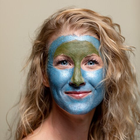 blonde female with 2 different creme masks applied
